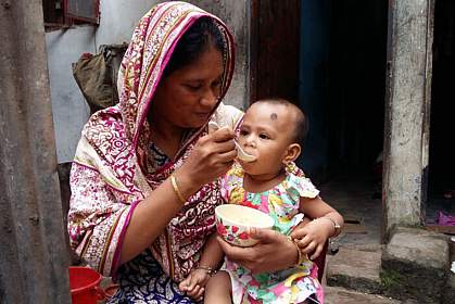 Mother feeding young child Mother feeding young child