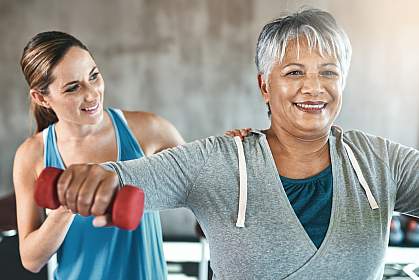 Older woman using weights with a physical therapist Older woman using weights with a physical therapist