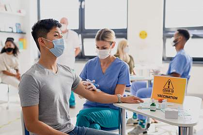 Man with face mask getting vaccinated in clinic Man with face mask getting vaccinated in clinic