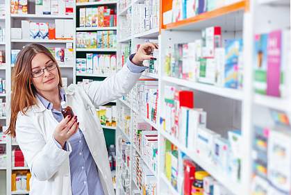 Woman pharmacist taking prescription drugs from shelf Woman pharmacist taking prescription drugs from shelf