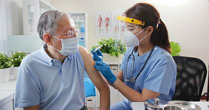 Nurse giving vaccination to senior person Nurse giving vaccination to senior person