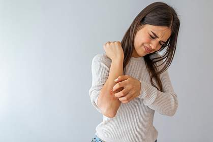Woman scratching her arm Woman scratching her arm