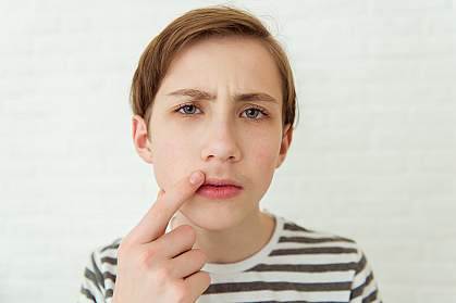 Teenage boy looking at his first mustache in a mirror Teenage boy looking at his first mustache in a mirror