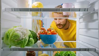 Man taking bowl of tomatoes from refrigerator Man taking bowl of tomatoes from refrigerator