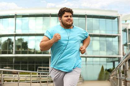 Young man with excess weight running outdoors Young man with excess weight running outdoors