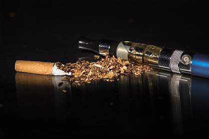 Unwrapped cigarette and e-cigarette on black background Unwrapped cigarette and e-cigarette on black background