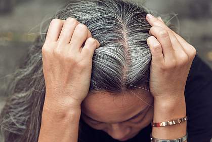 Top view of woman holding gray hair with both hands. Top view of woman holding gray hair with both hands.