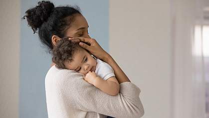 Mother holding infant against chest. Mother holding infant against chest.