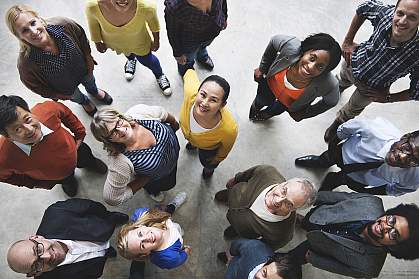 Bird’s-eye view of diverse people looking up and smiling. Bird’s-eye view of diverse people looking up and smiling.