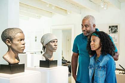 People looking at forensic facial reconstructions of two enslaved African American workers. People looking at forensic facial reconstructions of two enslaved African American workers.