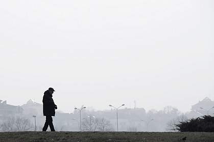 Silhouette of elderly man walking alone outside a city on a hazy, polluted day. Silhouette of elderly man walking alone outside a city on a hazy, polluted day.
