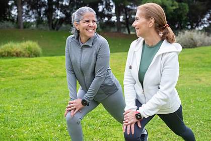 Women stretching together in a park. Women stretching together in a park.