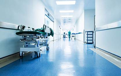 Medical worker blurred in the distance down an otherwise deserted hospital hallway. Medical worker blurred in the distance down an otherwise deserted hospital hallway.