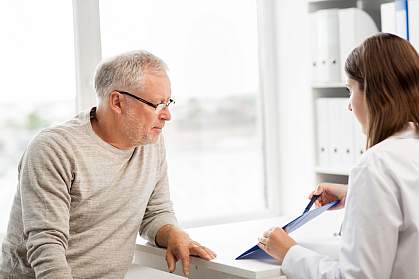 Doctor showing something on a clipboard to a senior man. Doctor showing something on a clipboard to a senior man.