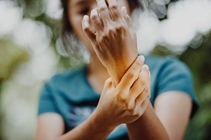 Close up of a young woman holding her wrist in pain or discomfort. Close up of a young woman holding her wrist in pain or discomfort.