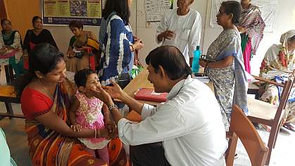 Child sits in mother’s lap during an examination in an Indian clinic. Child sits in mother’s lap during an examination in an Indian clinic.