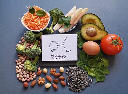 Foods rich in vitamin B3, or niacin, around a drawing of a niacin molecule. Foods rich in vitamin B3, or niacin, surround a drawing of a niacin molecule: avocado, nuts, spinach, bean, broccoli, egg, tomato, and chicken breast slices.