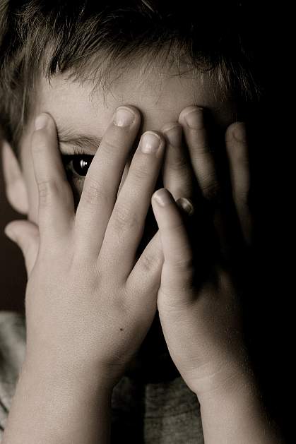 Child hiding face and looking through his fingers. Child hiding face and looking through his fingers.