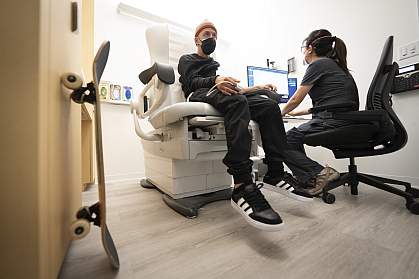 Man in hospital chair getting his vitals monitored by a technician. Man in hospital chair getting his vitals monitored by a technician.