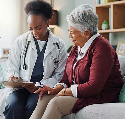 Elderly Latina woman speaking to a young Black woman doctor Elderly Latina woman speaking to a young Black woman doctor.