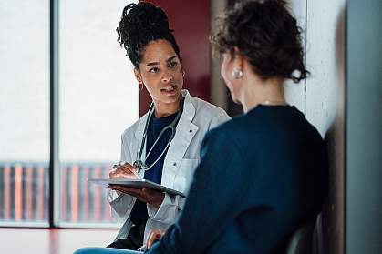 Doctor with a tablet speaking to a hospital patient. Doctor with a tablet speaking to a hospital patient.