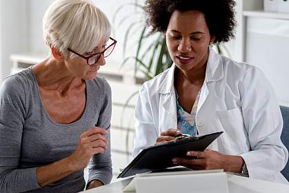 Female doctor speaking with an elderly female patient while looking at test results. Female doctor speaking with an elderly female patient while looking at test results.