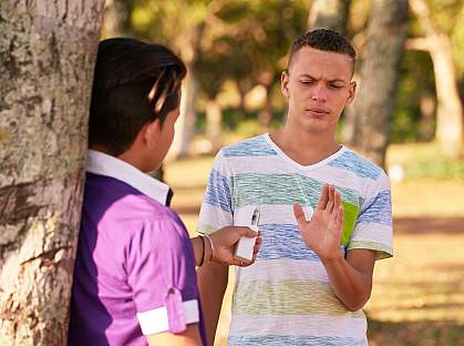 Teenager in a park turning down an electronic cigarette. Teenager in a park turning down an electronic cigarette.