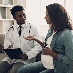 Doctor in White Uniform Consulting Pregnant Woman.