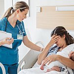 Image of a woman in a hospital bed holding a baby