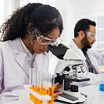 Image of a scientist looking through a microscope