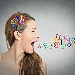 Side view portrait of a woman talking with alphabet letters in her head and coming out of her open mouth.