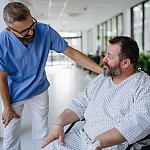 Doctor talking with an overweight patient in a wheelchair.