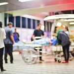 Blurred photograph of a patient being transferred from an ambulance.