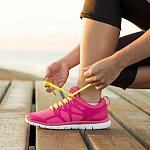 Woman tying her running shoe laces.