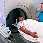 Technician preparing man for a CT scan.